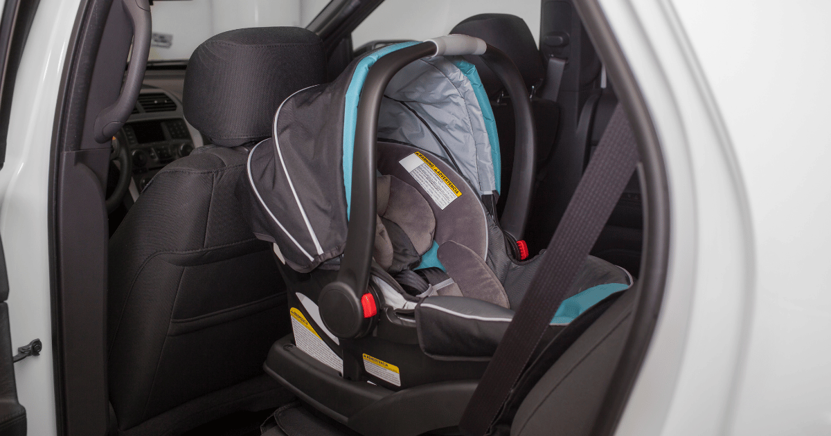 Infant car seat installed in the back seat of a vehicle.